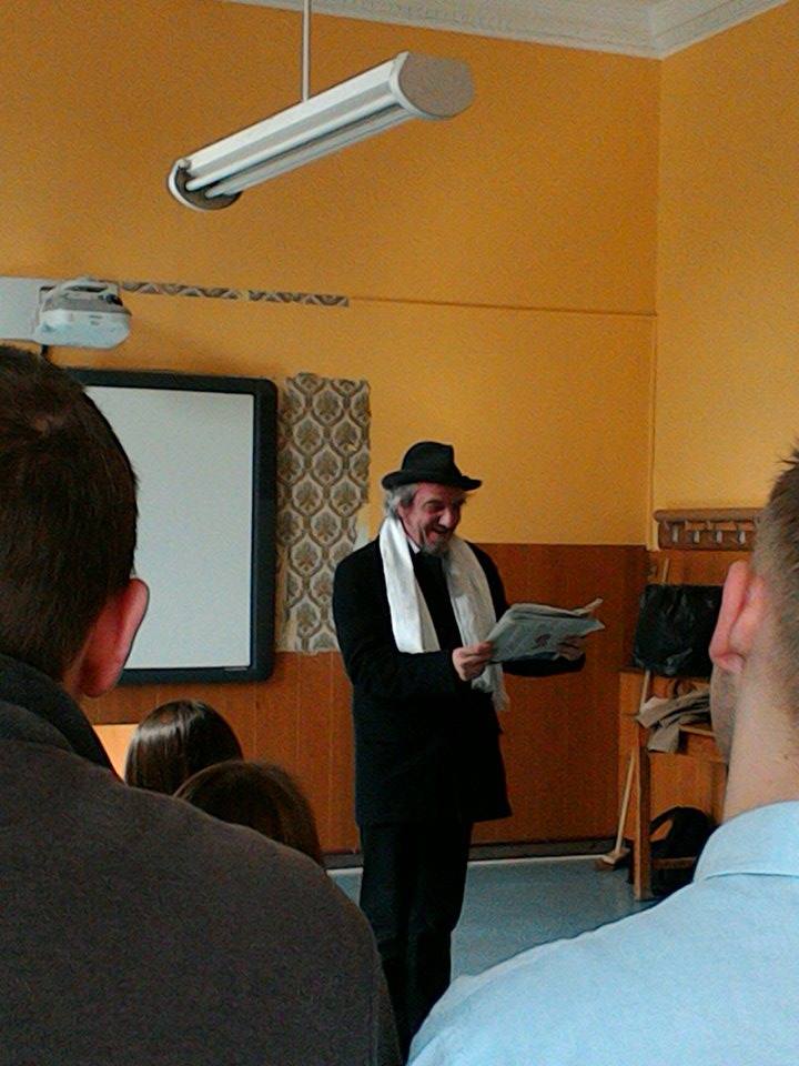 Comédien en costume de poète lisant un livre